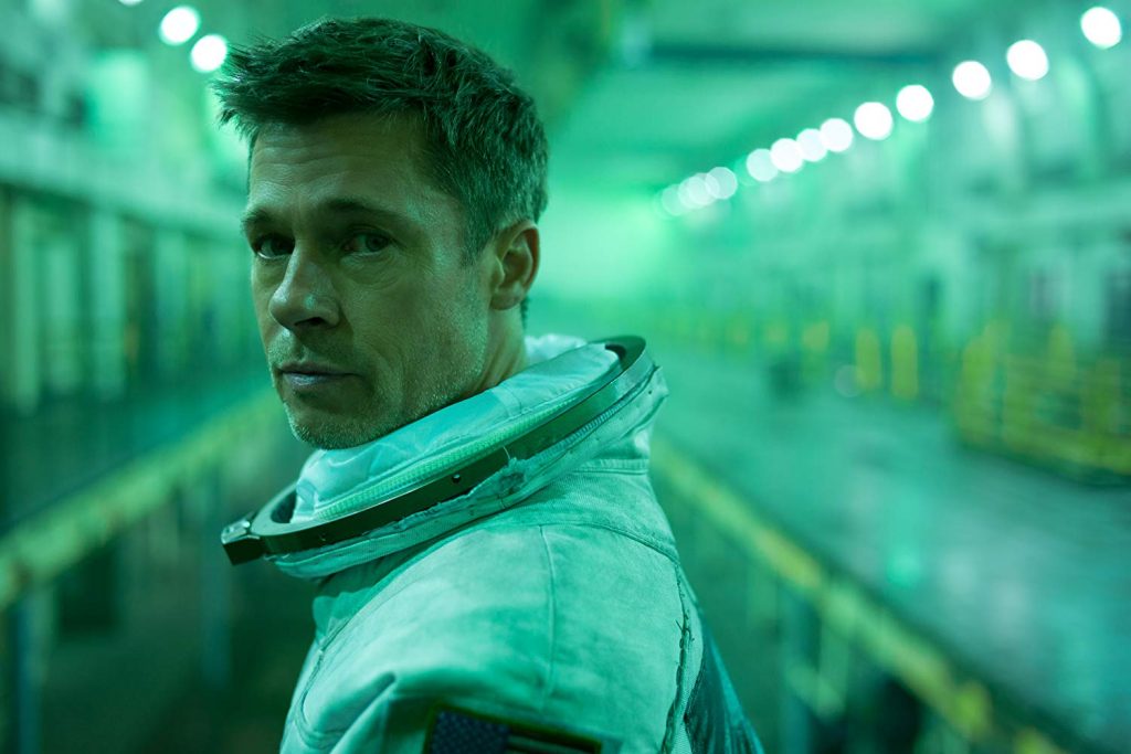 Brad Pitt stands in front of a green corridor in Ad Astra