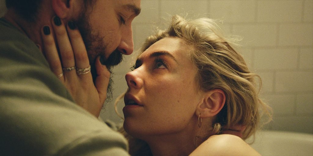 Vanessa Kirby and Shia LaBoeuf stand close to each other touching their faces in Pieces of a Woman