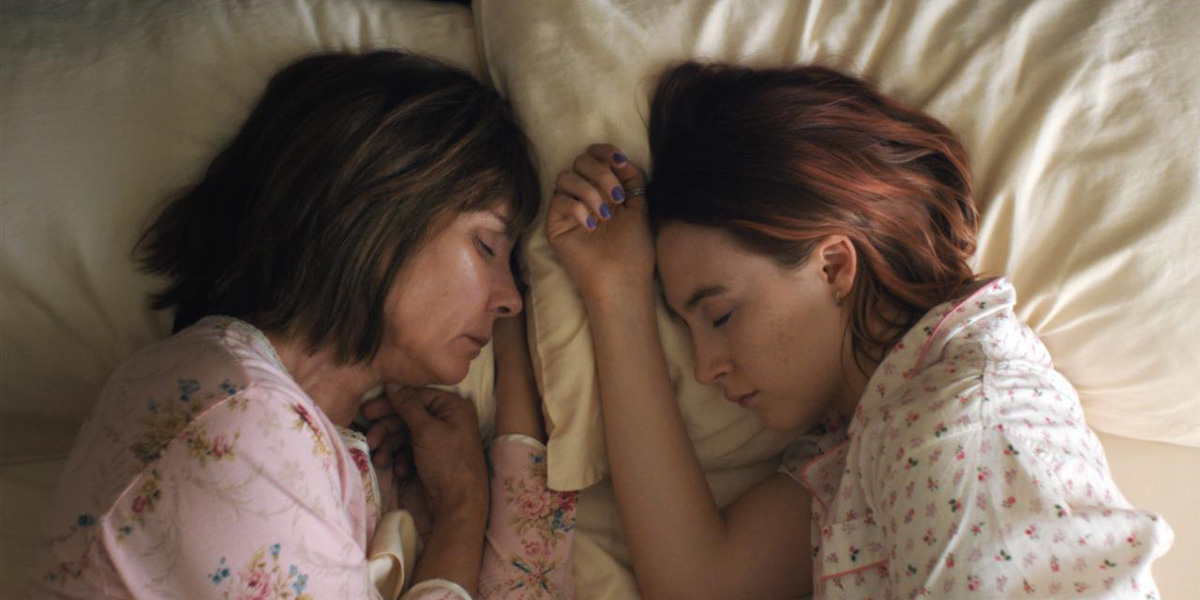Lady Bird and her mother lie in bed in front of each other with eyes closed in the Greta Gerwig directed movie Lady Bird