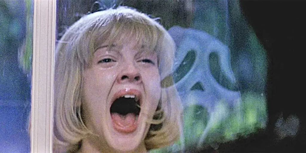 Drew Barrymore screams looking at Ghostface in the reflection of her window in the movie Scream (1996)