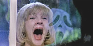 Drew Barrymore screams looking at Ghostface in the reflection of her window in the movie Scream (1996)