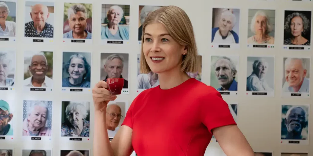 I Care a Lot: Rosamund Pike with pictures behind her