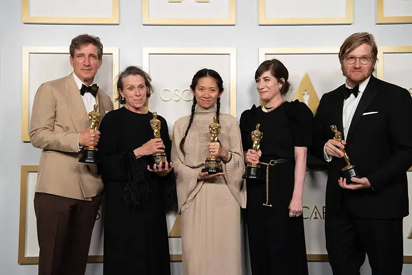 Chloé Zhao poses with fellow 2022 Oscar winners, all holding  their Academy Awards, in a still featured on a Loud and Clear Reviews article on why the Oscars are taken too seriously