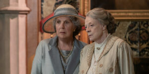 Dame Maggie Smith and Imelda Staunton stand together looking at something in Downton Abbey: A New Era