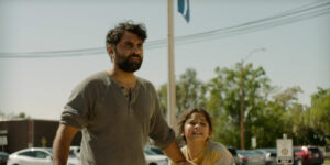 A man and his daughter stand on a road in a still from the film Land of Gold