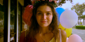 A woman smiles with balloons behind her in Cherry