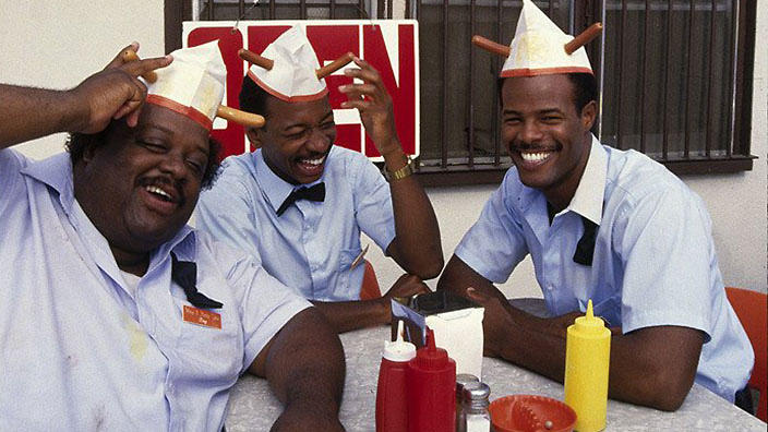 three characters sit at a table in the film Hollywood Shuffle