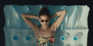 A woman leans on a water mattress in a still from the film Amanda