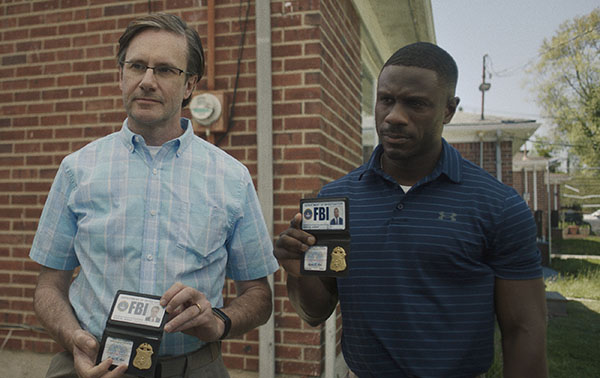 Josh Hamilton and Marchánt Davis show their FBI badges in the 2023 film Reality