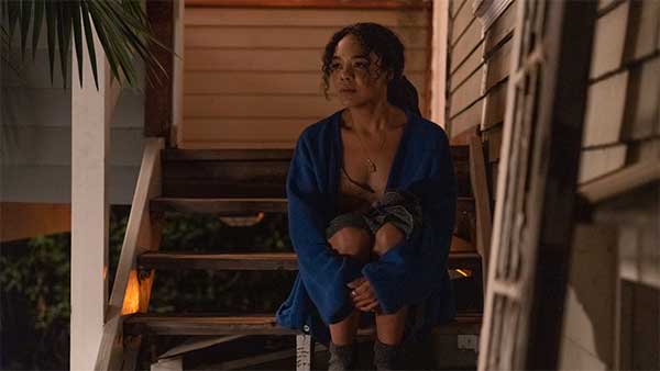 Rebecca Hall sits on the stairs in the film The Listener