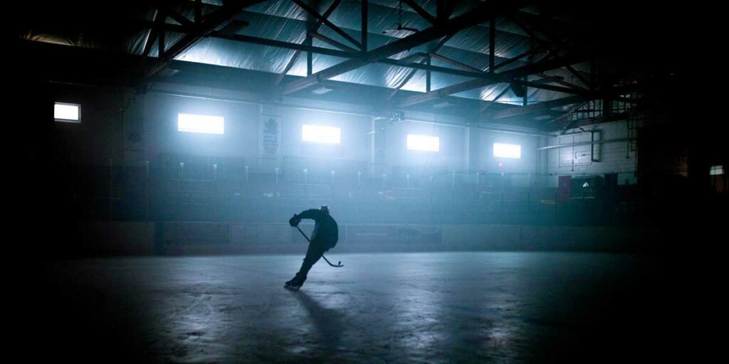 A man plays hockey alone at night in the film Black Ice, a great film about ice hockey