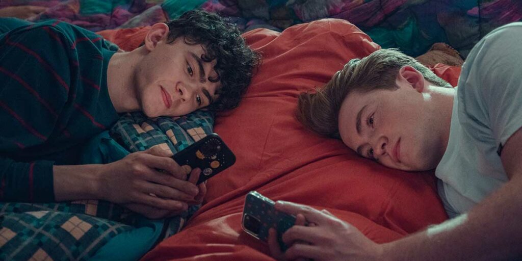 Nick (Kit Connor) and Charlie (Joe Locke) text each other in bed in Heartstopper Season 2