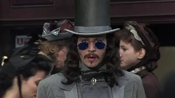 Gary Oldman wears blue glasses and a grey suit and hat in the Coppola movie Bram Stoker's Dracula