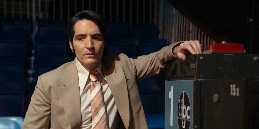 David Dastmalchian leans on a camera in the film Late Night with the Devil