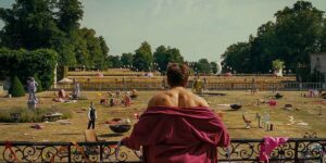 Barry Keoghan looks at the estate from the balcony in the film Saltburn