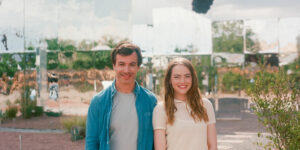 Nathan Fielder as Asher and Emma Stone as Whitney stand together smiling in The Curse season 1