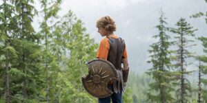 Percy Jackson stands alone holding his shield in episode 1