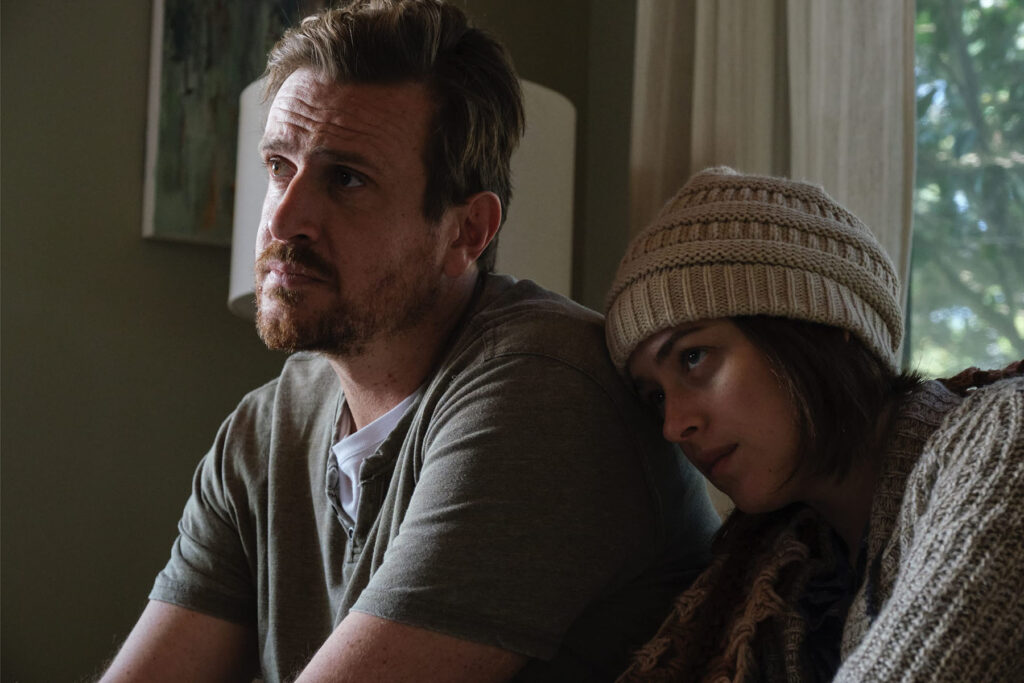 Jason Segel and Dakota Johnson leaning on each other in the film Our Friend