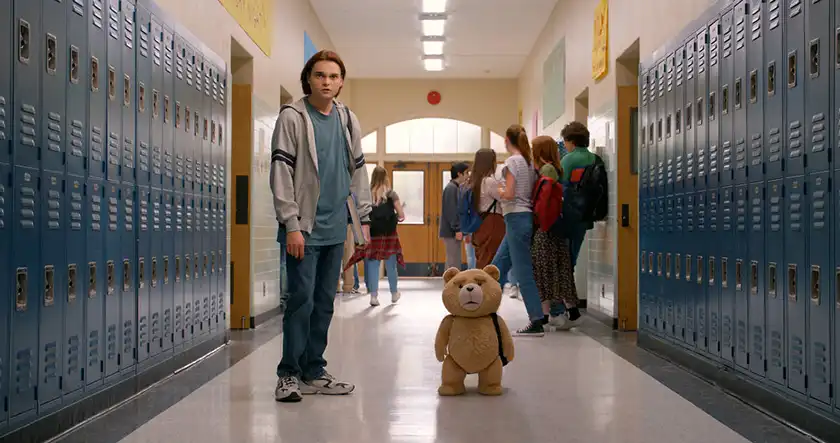 Max Burkholder and Ted by the school lockers in an episode of the Peacock series Ted