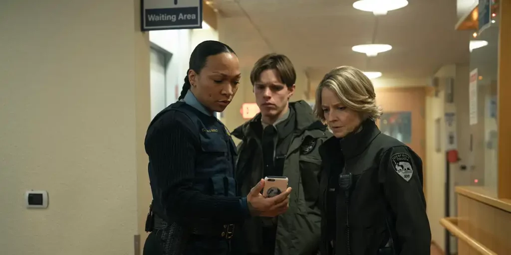 Kali Reis, Finn Bennett and Jodie Foster look at a phone in Episode 3 of True Detective: Night Country