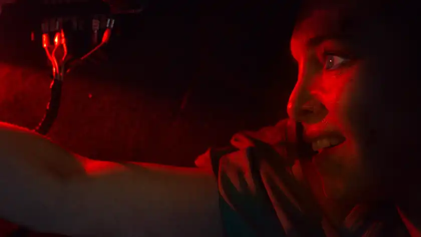 Sina Martens is locked in a car with some cables in the film Trunk: Locked In