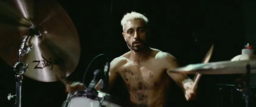 Riz Ahmed plays the drums in the film Sound of Metal, one of the movies to watch if you feel lost