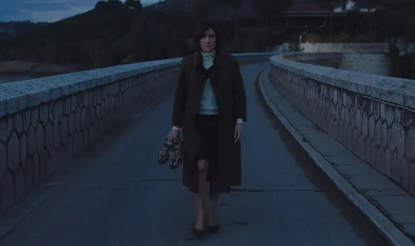 Angeliki Papoulia walks with her shoes in her hands in the film Arcadia