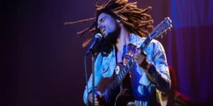 Kingsley Ben Adir plays the guitar in a scene from the movie Bob Marley: One Love
