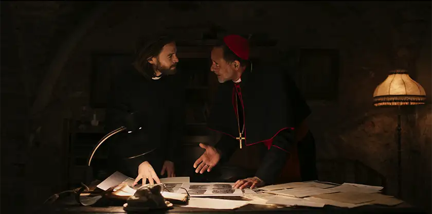 A priest and a cardinal argue over a map in the religious horror film Deliver Us