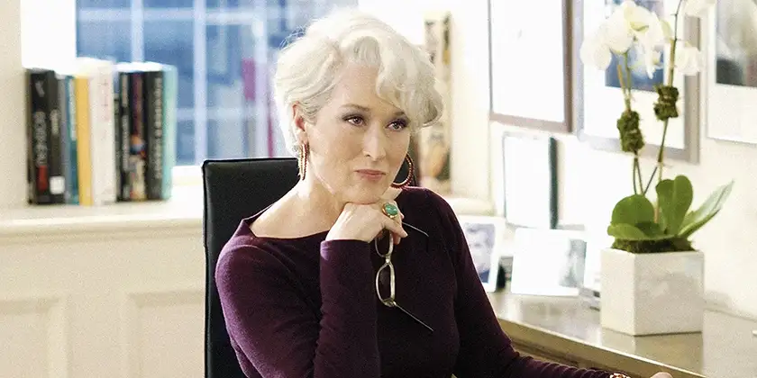 Meryl Streep sits behind her desk as Miranda Priestley in The Devil Wears Prada