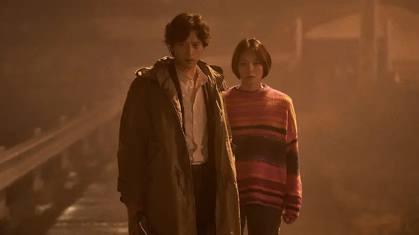 A man and a woman stand in the fog, looking determined, in the film Dr. Cheon and the Lost Talisman