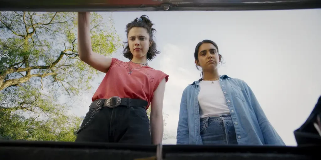 Margaret Qually and Geraldine Viswanathan open a car boot in Drive-Away Dolls