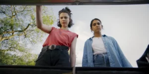 Margaret Qually and Geraldine Viswanathan open a car boot in Drive-Away Dolls