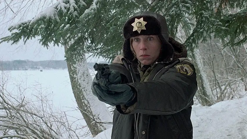 Frances McDormand, the sheriff, points a gun at someone in the movie Fargo, which seamlessly blends crime and comedy