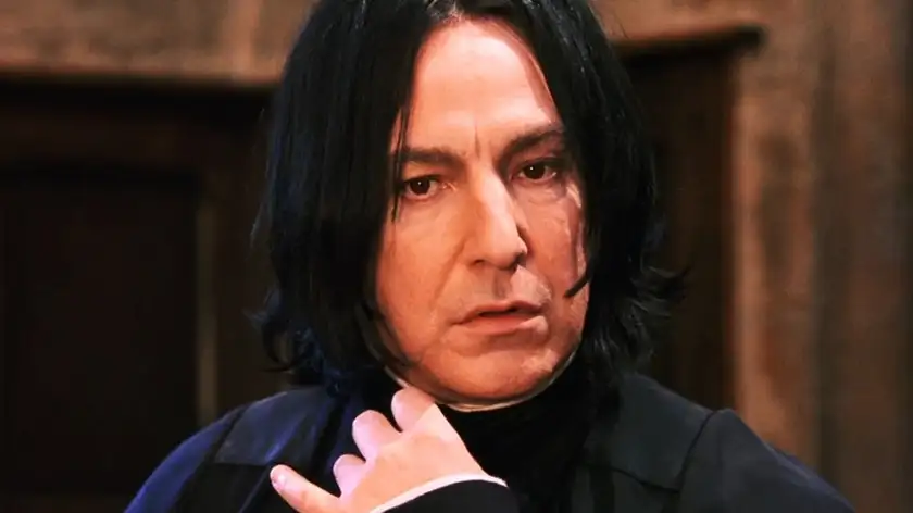 Alan Rickman has a hand on his neck and an intense stare as Professor Severus Snape in Harry Potter
