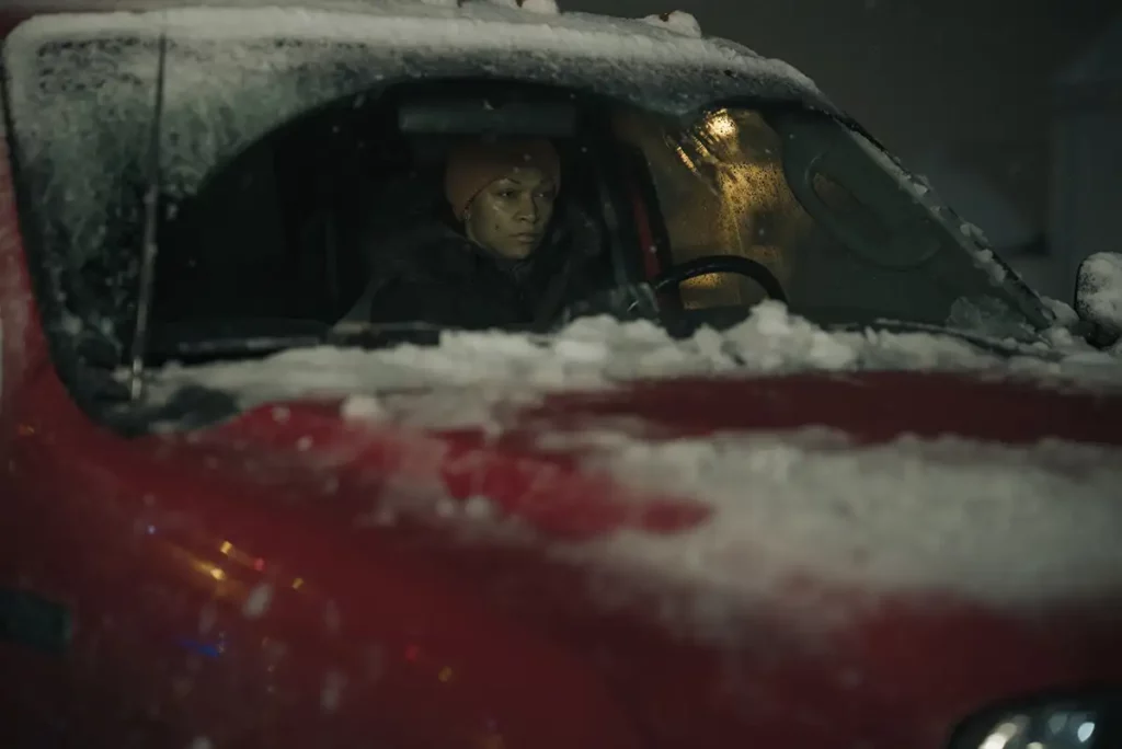Kali Reis sits inside a red car with a grim expression on her face in Episode 5 of True Detective: Night Country