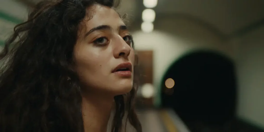 A shot of Deba Hekmat's face with the London underground behind her in the film Last Swim