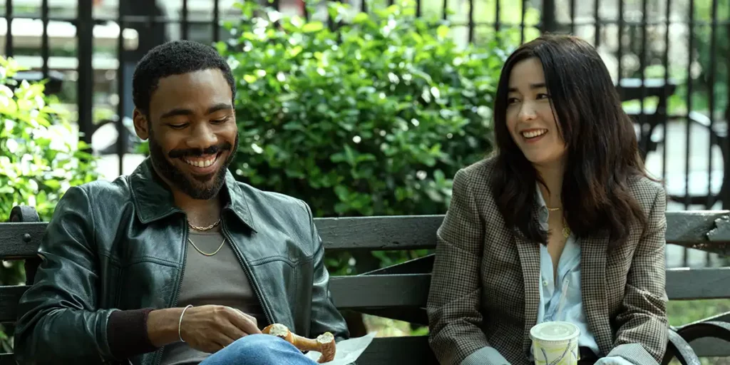 Maya Erskine and Donald Glover sit on a bench in Mr. & Mrs. Smith
