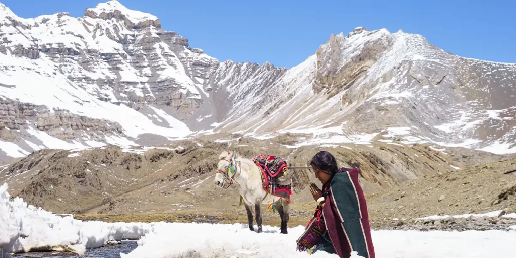 Thinley Lhamo sit next to a donkey in the film Shambhala