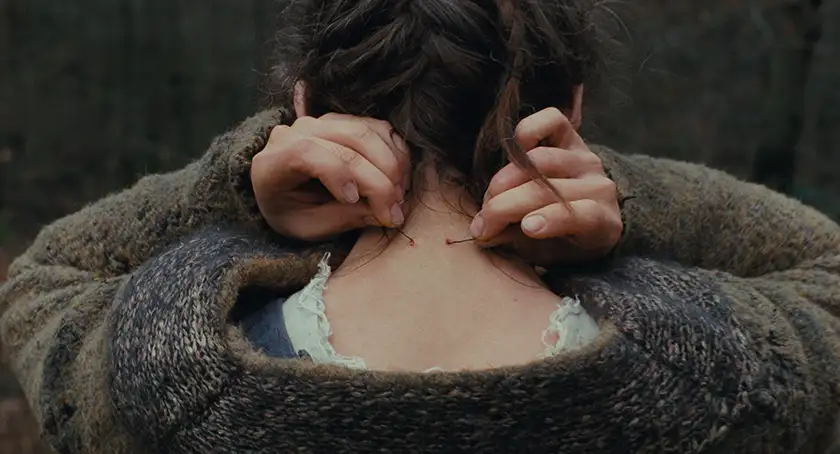 Anja Plaschg with holes in the back of her neck in the film The Devil's Bath