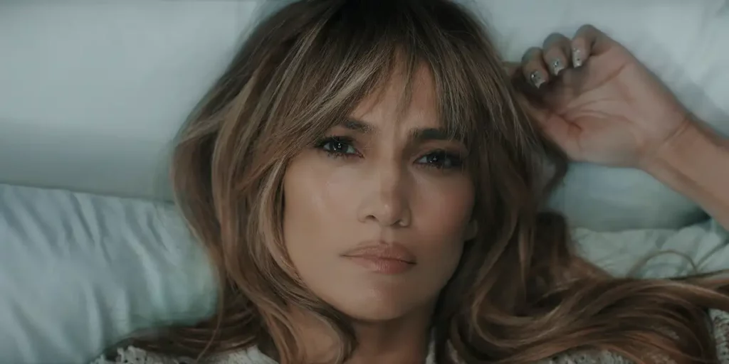 Jennifer Lopez looks at the camera while in bed in the film This Is Me...Now: A Love Story