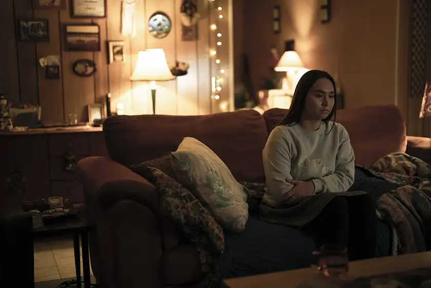 Isabella Star LaBlanc sits on the couch in Episode 6 of True Detective: Night Country