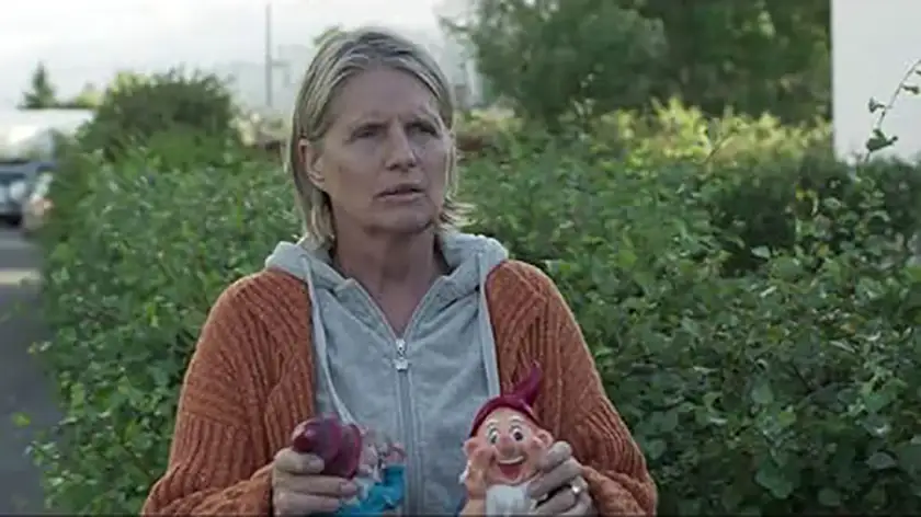 a woman holds two garden gnomes in the movie Under the Tree