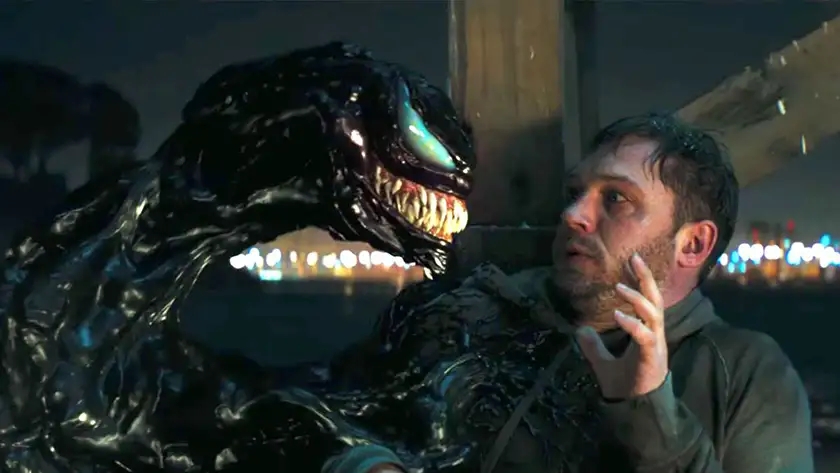 Venom and Tom Hardy look at each other in the film Venom