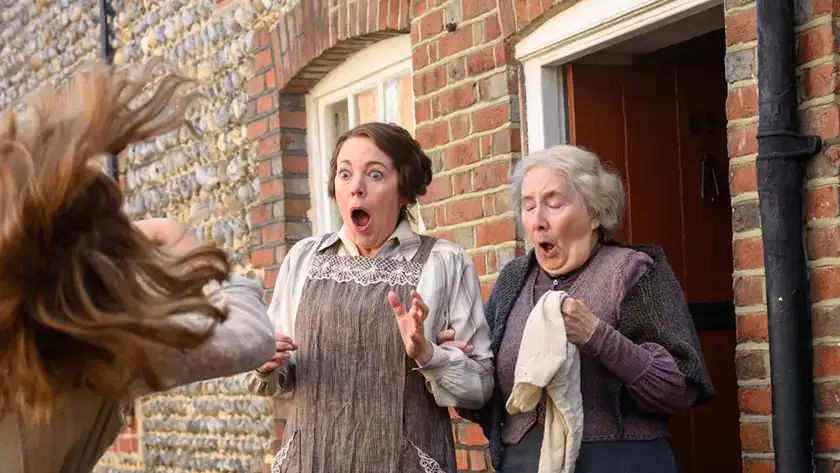 Olivia Colman and a woman both gasp, facing an unseen person in the film Wicked Little Letters