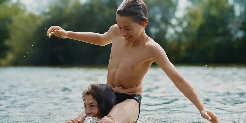 Two boys play in the water in the film Young Hearts, now at the 2024 Berlin Film Festival.