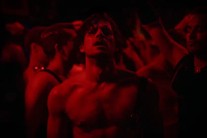 A red shot of a topless man in the film High Tide