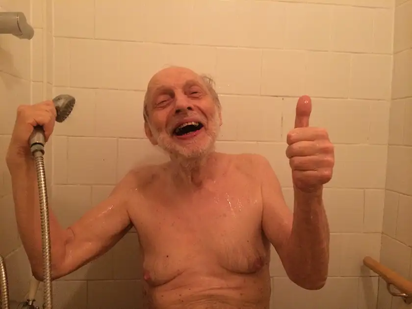 Uncle David smiles while taking a shower in Simon Chambers' film Much Ado About Dying