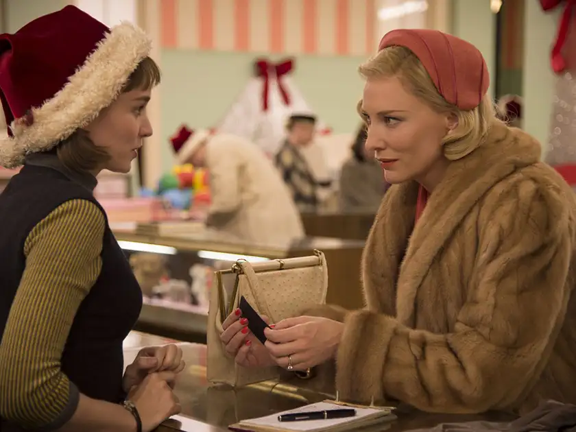 Cate Blanchett and Rooney Mara look at each other in a store in Carol