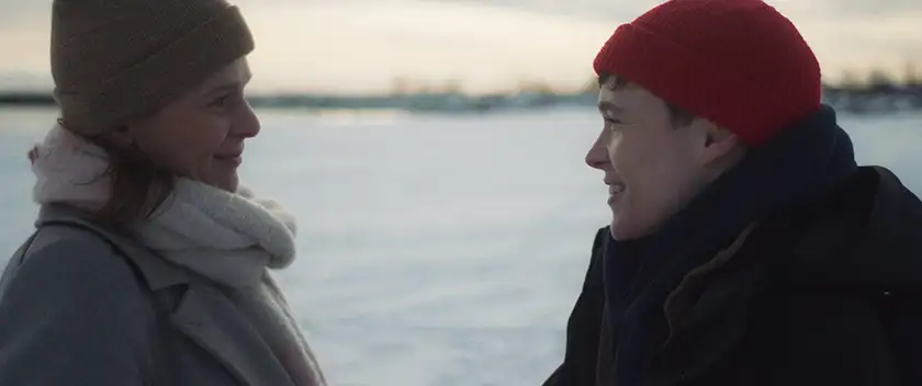 Two people look at each other smiling by the lake in the 2024 film Close to You